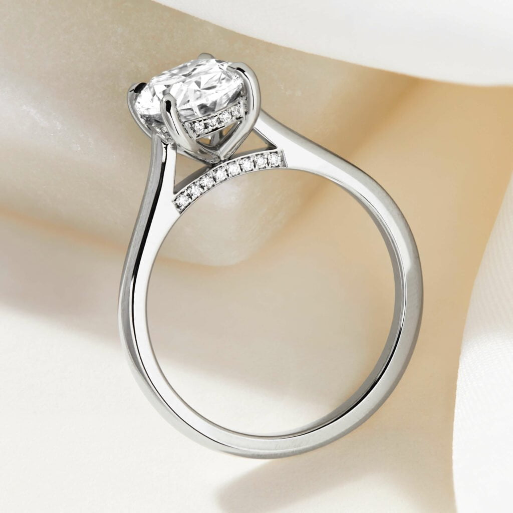 Custom engagement ring with diamond bezel and diamond bridge